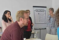 Bild von Pascal Ackerschott, Leiter des Design Thinking-Workshops und einiger Teilnehmenden im Austausch
