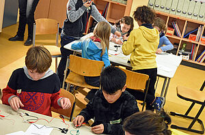 Kinder forschen mit Strom in einem Klassenzimmer.